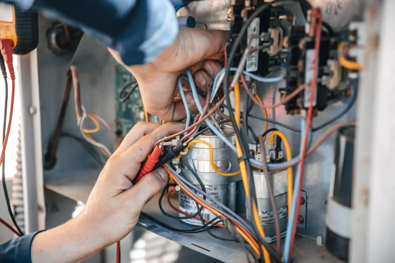 Man Fixing Wiring In Furnace HVAC Repair